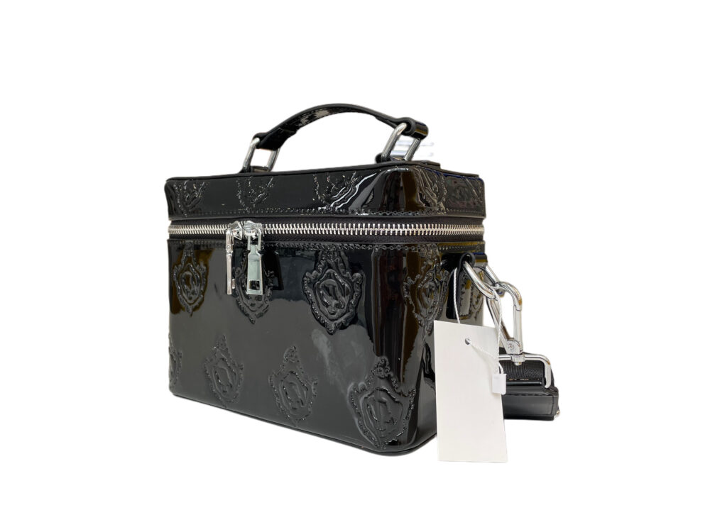 Black patent leather vanity bag with silver hardware, featuring a sleek strap for versatile use a toiletry bag, cosmetic bag, or purse.